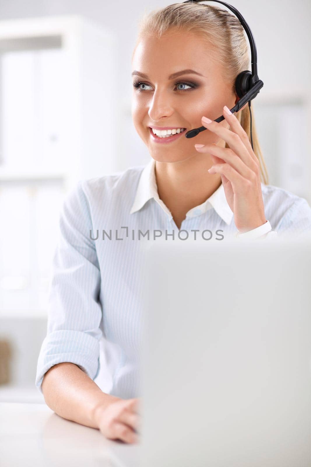 Close-up portrait of a customer service agent sitting at office by lenetstan