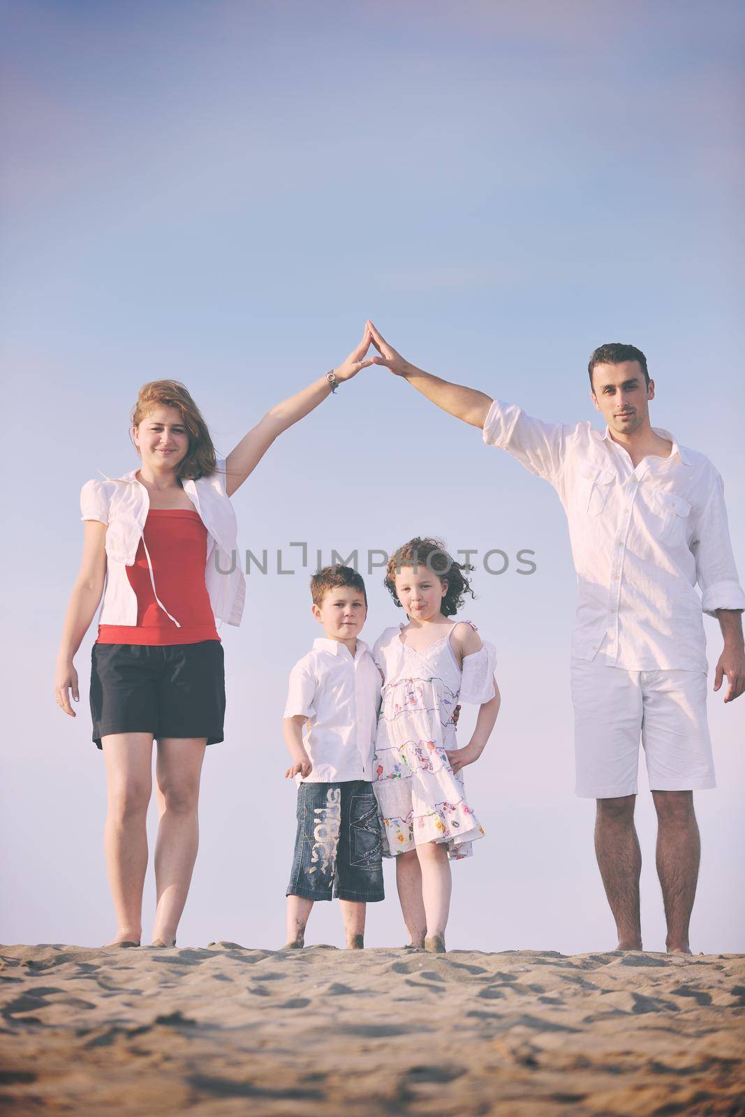family on beach showing home sign by dotshock