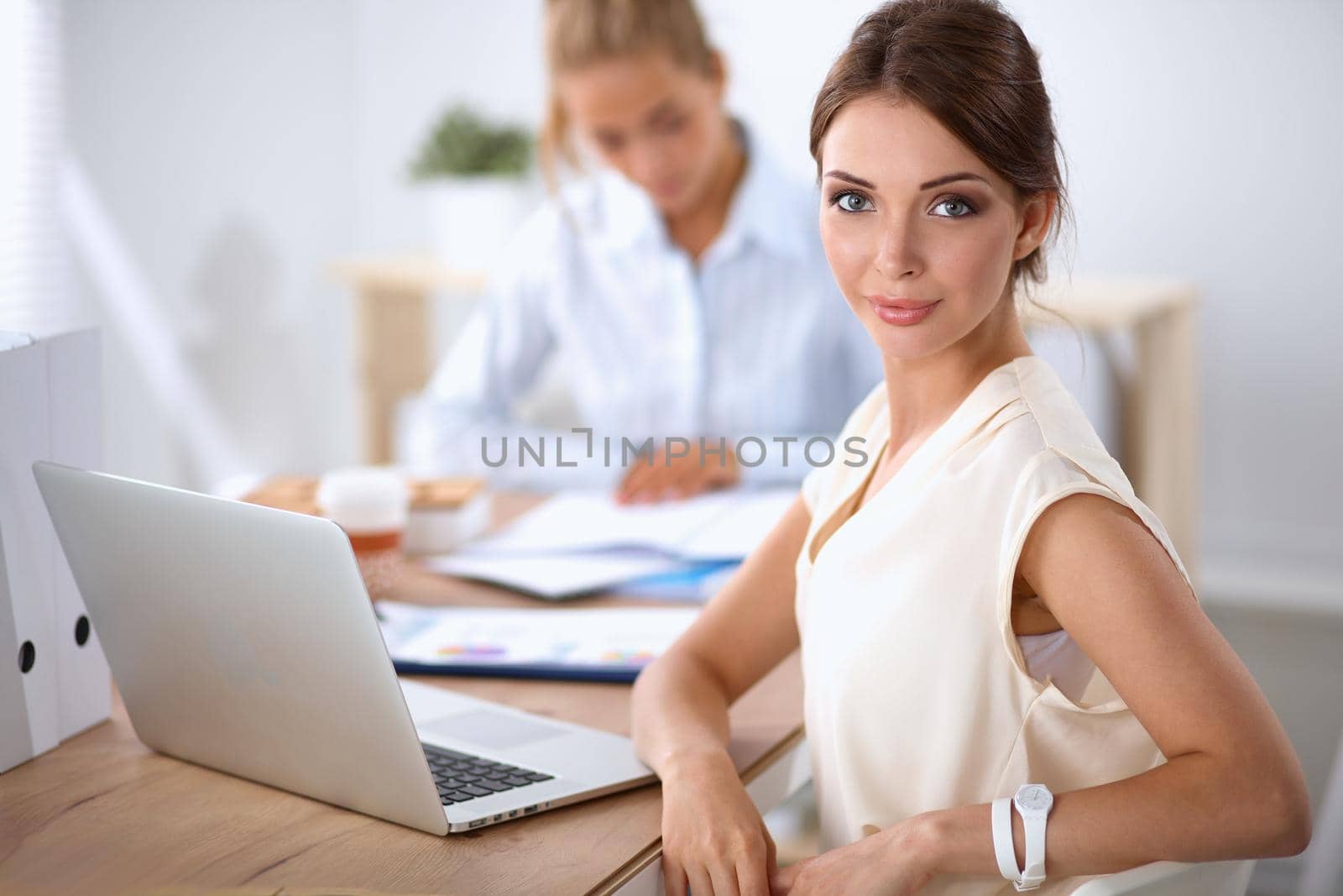 Beautiful businesswoman enjoying coffee in bright office, sitting