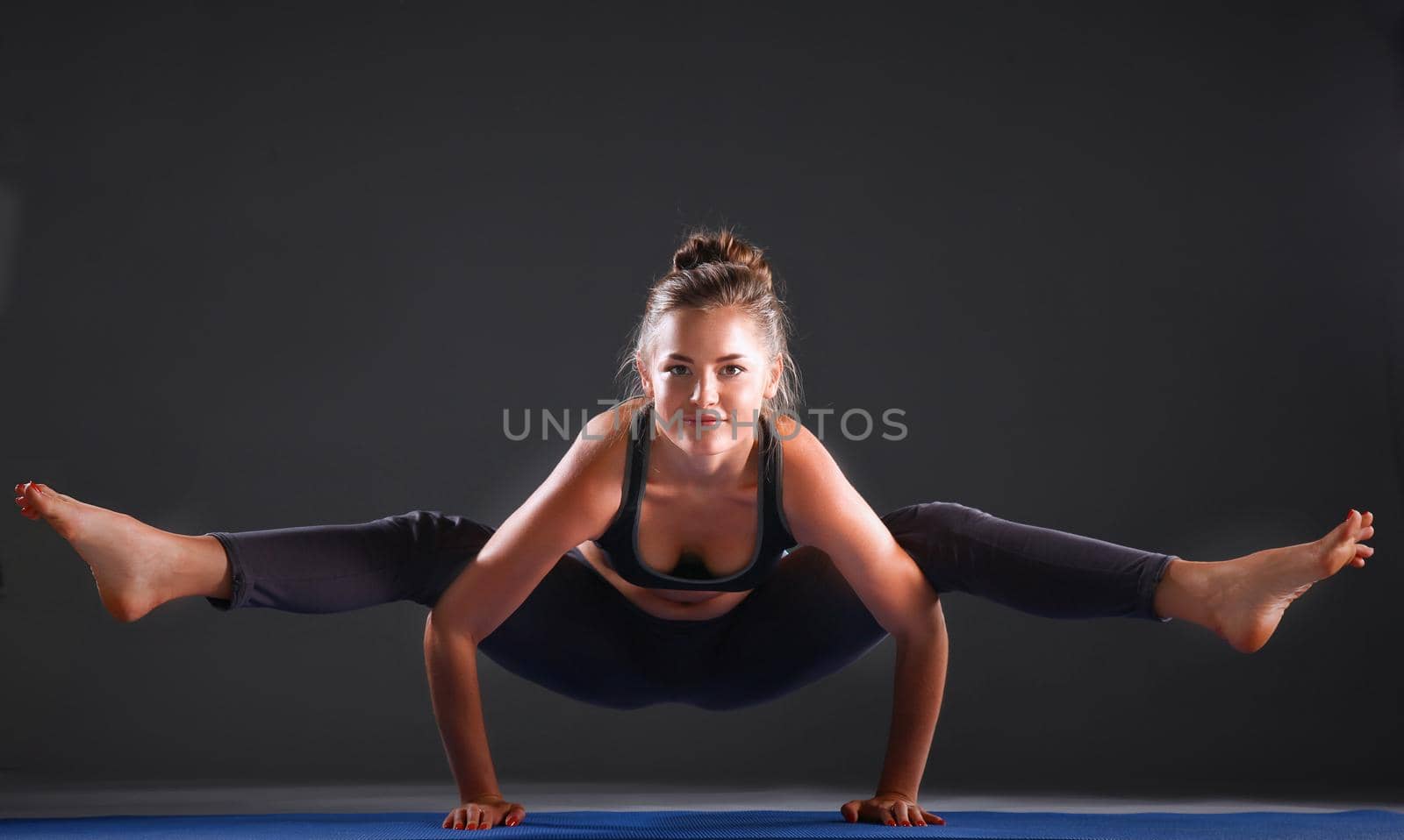 Portrait of sport girl doing yoga stretching exercise .