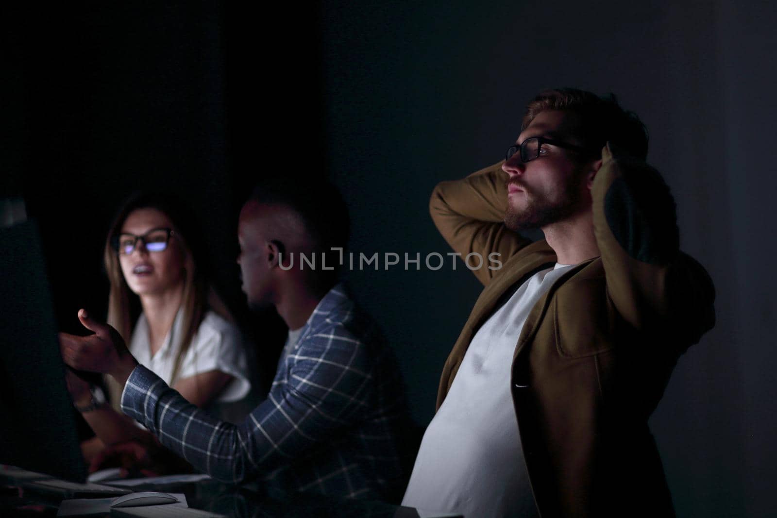 close up.serious businessman on the background of colleagues .photo on black background