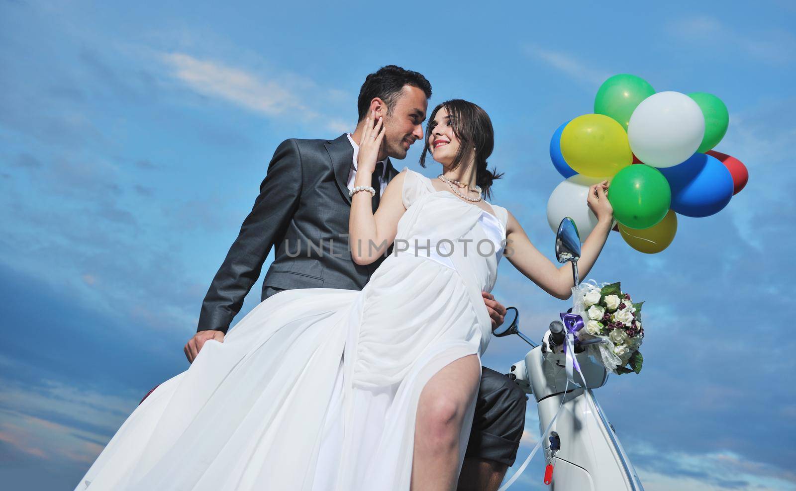 wedding sce of bride and groom just married couple on the beach ride white scooter and have fun