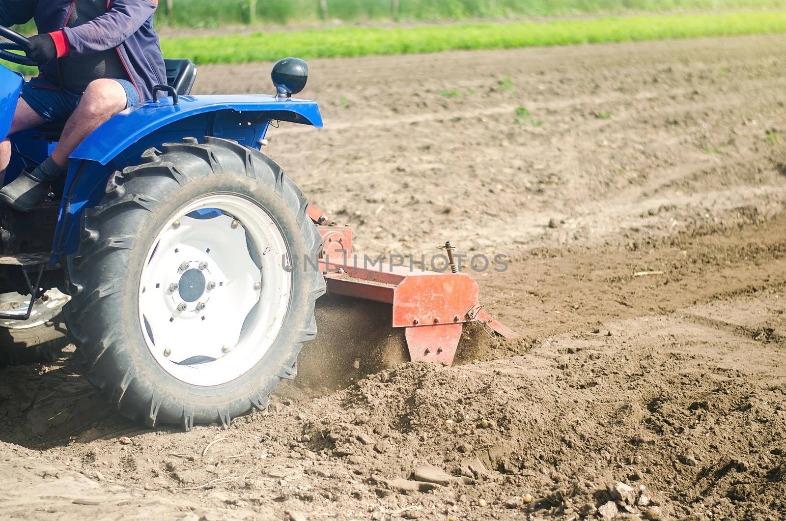 Tractor with milling machine loosens, grinds and mixes soil. Farming and agriculture. Loosening the surface, cultivating the land for further planting. Cultivation technology equipment by iLixe48