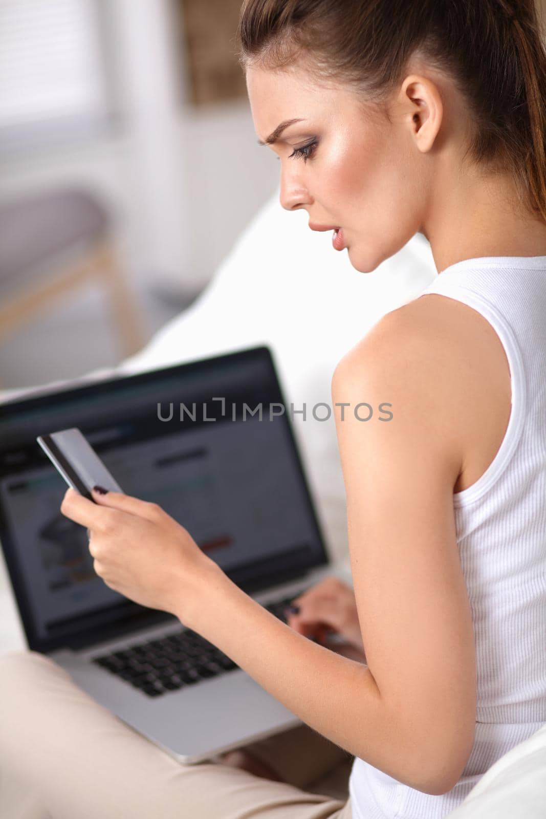 Woman shopping online with credit card and computer.
