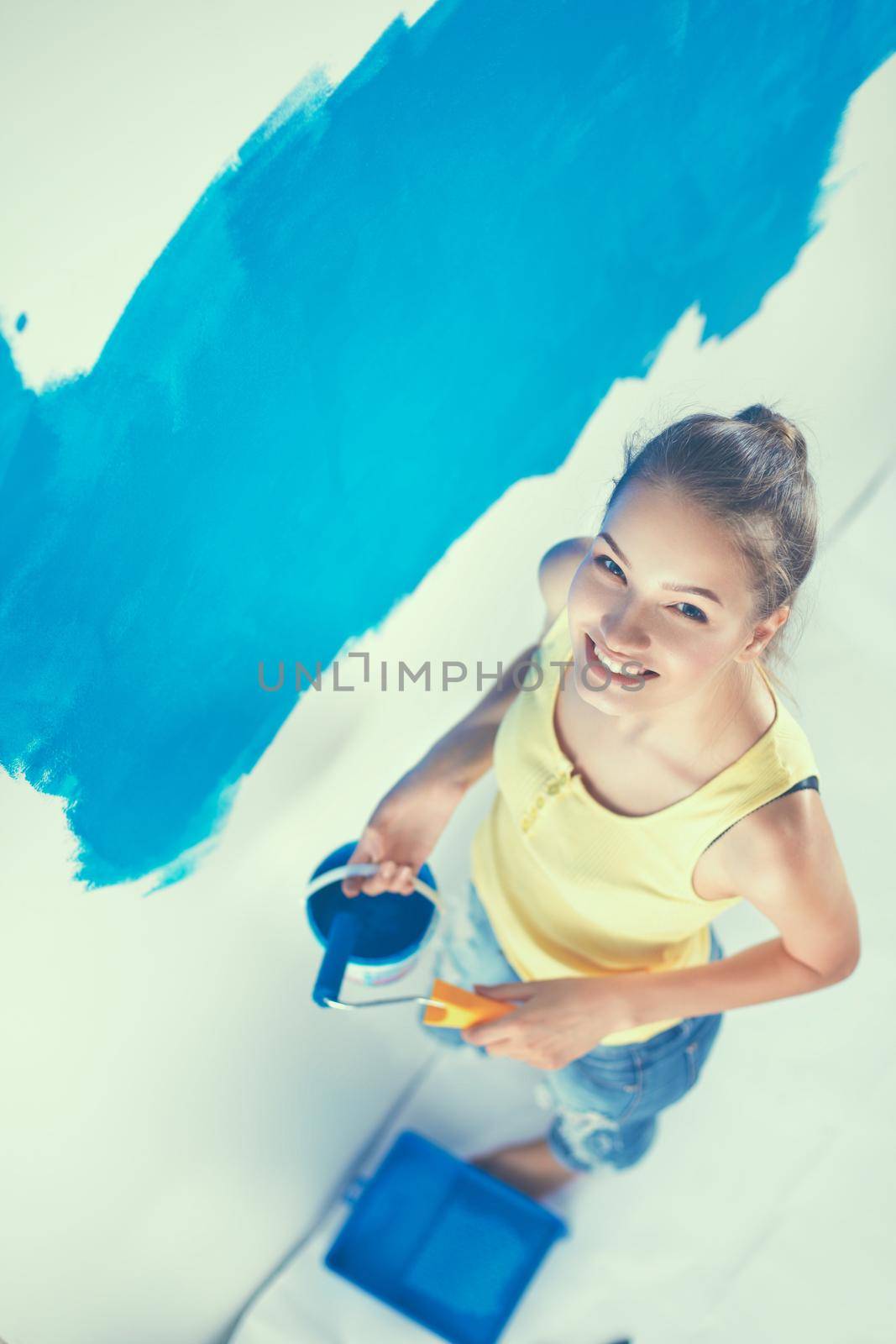 Beautiful young woman doing wall painting by lenetstan