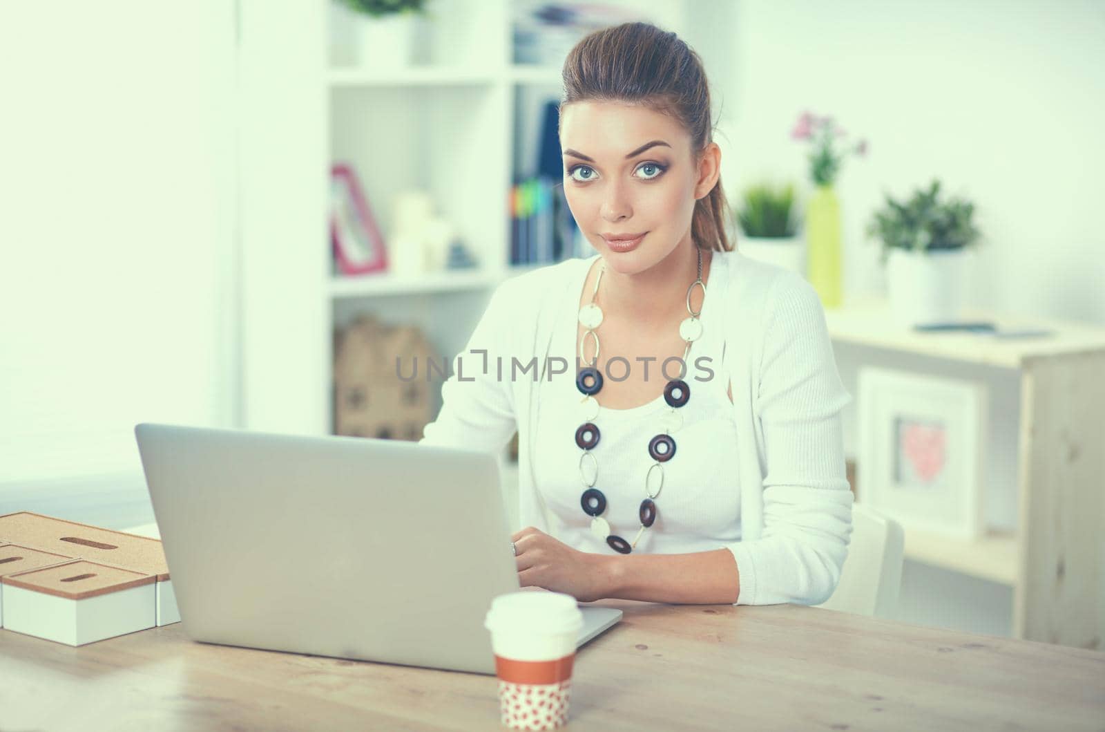 Portrait of a businesswoman sitting at a desk with a laptop.