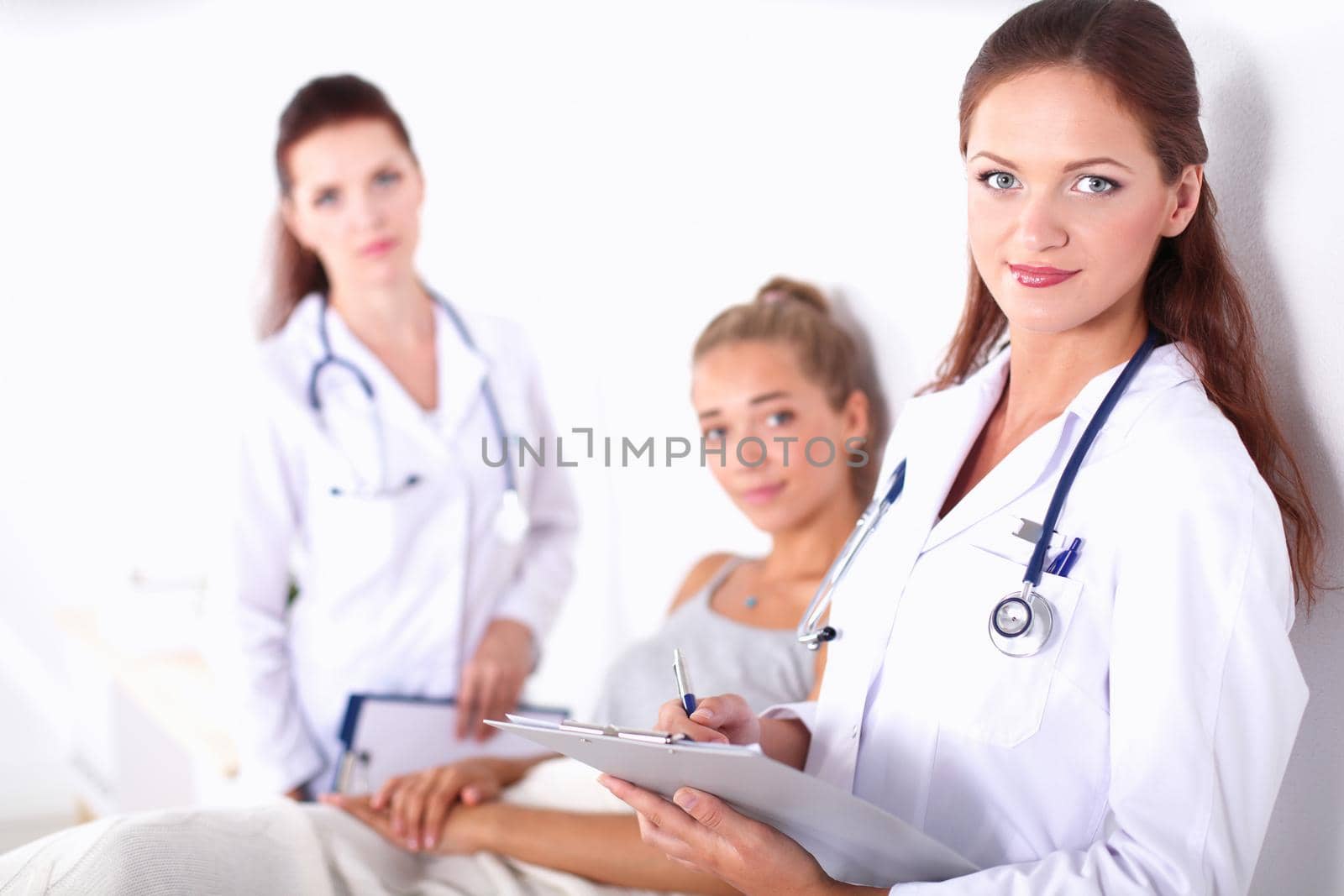 Smiling female doctor with a folder in uniform standing