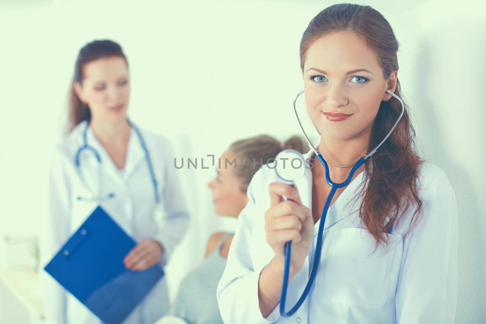 Woman doctor with folder standing at hospital.