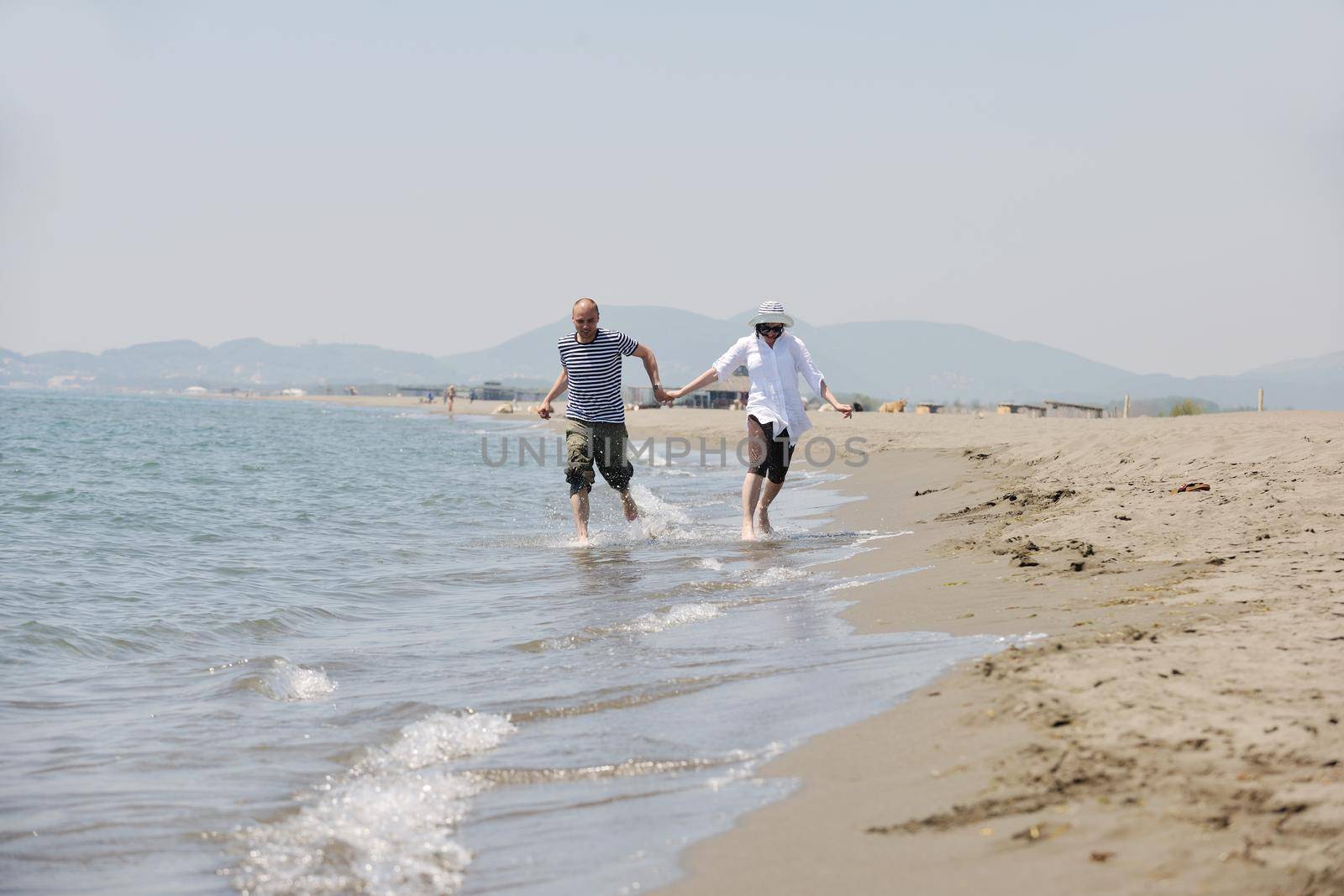 happy young couple have fun and romantic moments on beach at summer season and representing happynes and travel concept