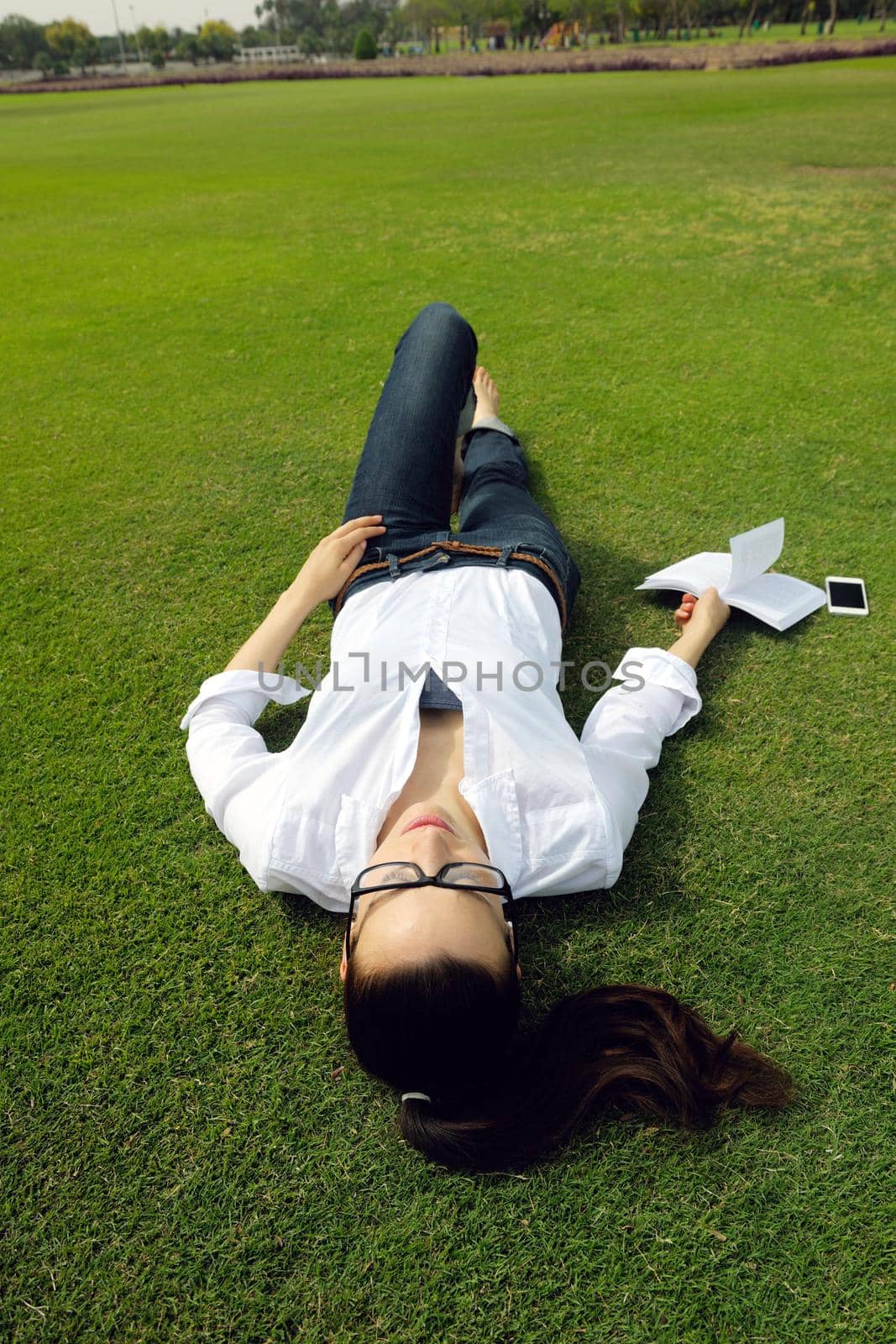 Young student woman reading a book and study in the park