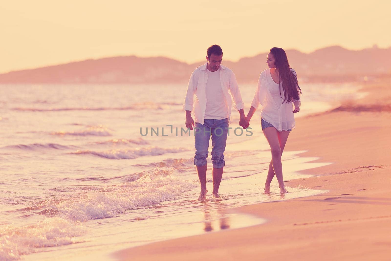 happy young romantic couple in love have fun on beautiful beach at beautiful summer day