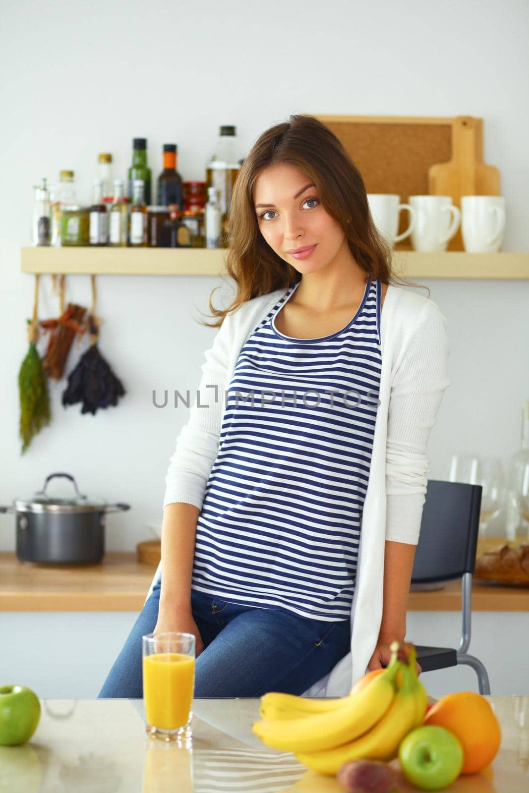 Young woman sitting near desk in the kitchen.