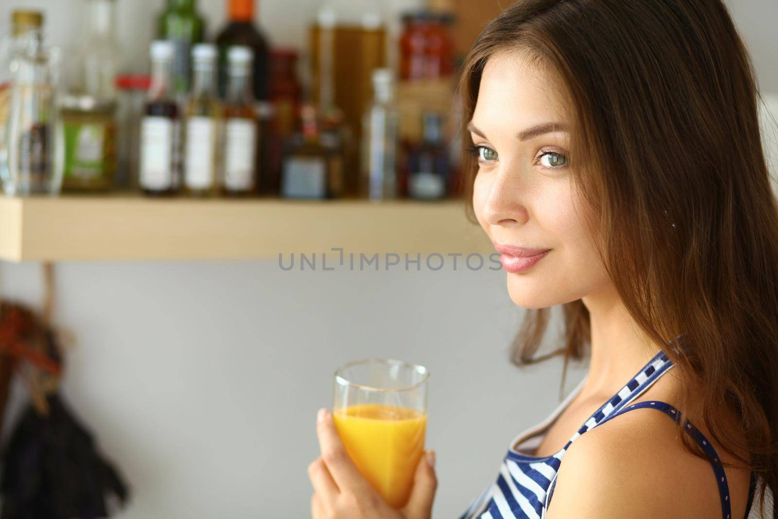 Portrait of a pretty woman holding glass with tasty juice.