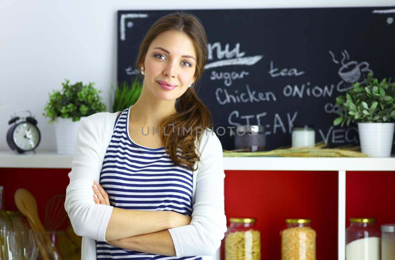 Young woman standing near desk in the kitchen by lenetstan