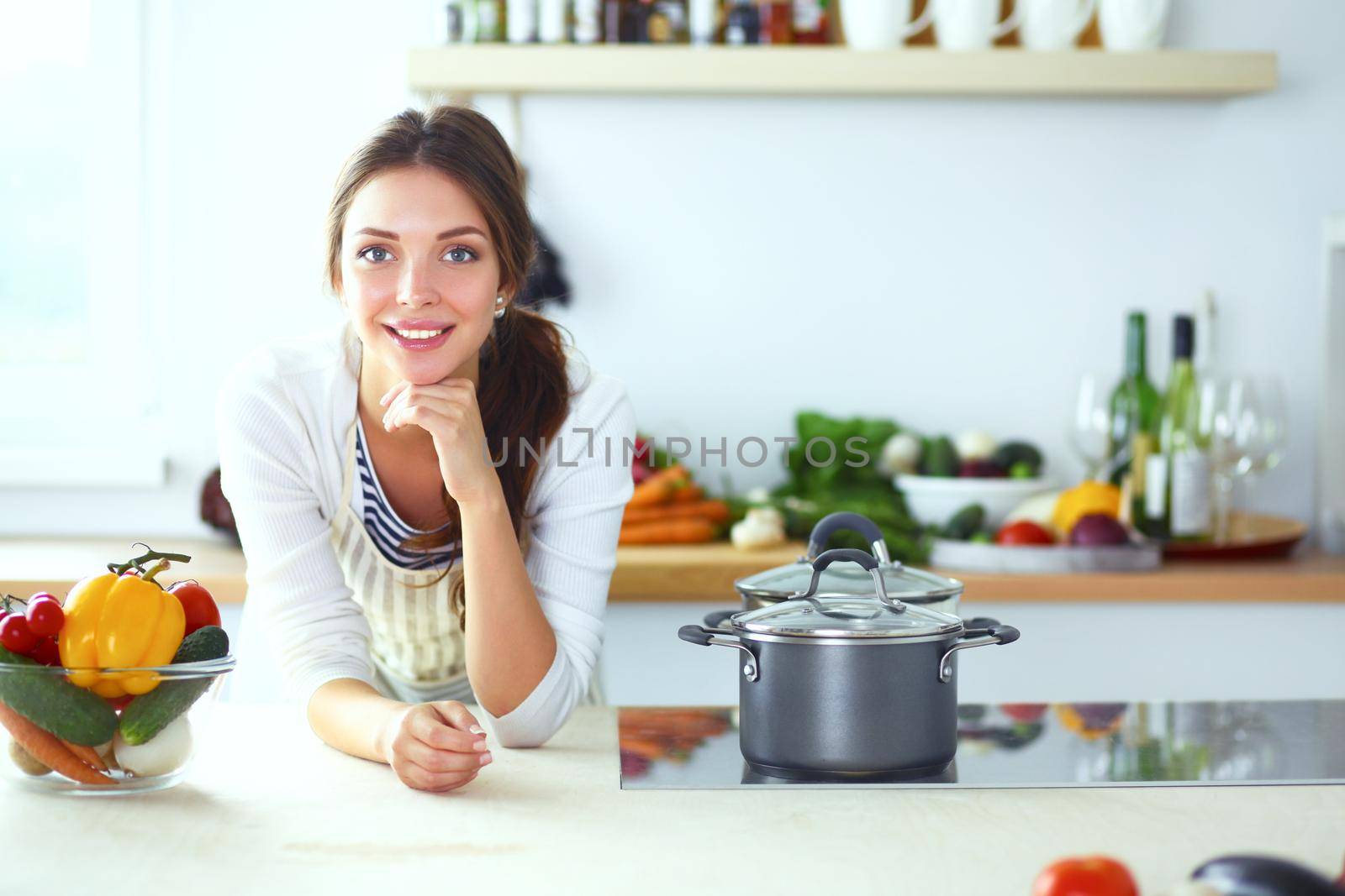 Young woman standing near desk in the kitchen by lenetstan