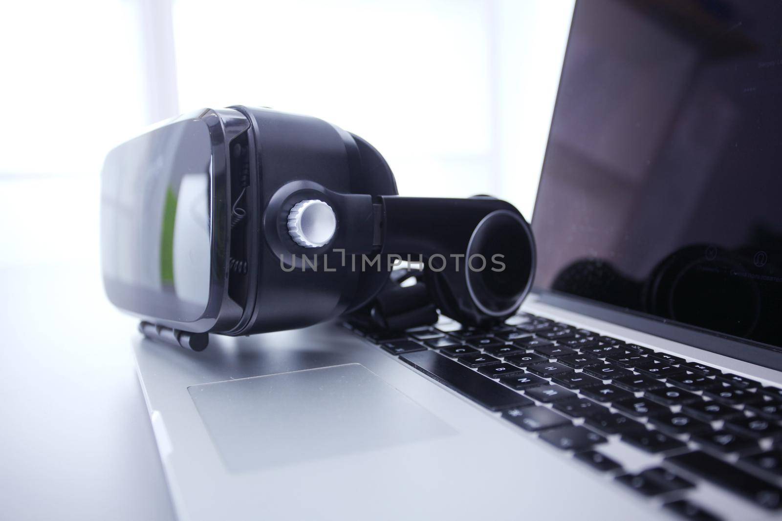 Virtual reality goggles on desk with laptop. business. 3d technology by lenetstan