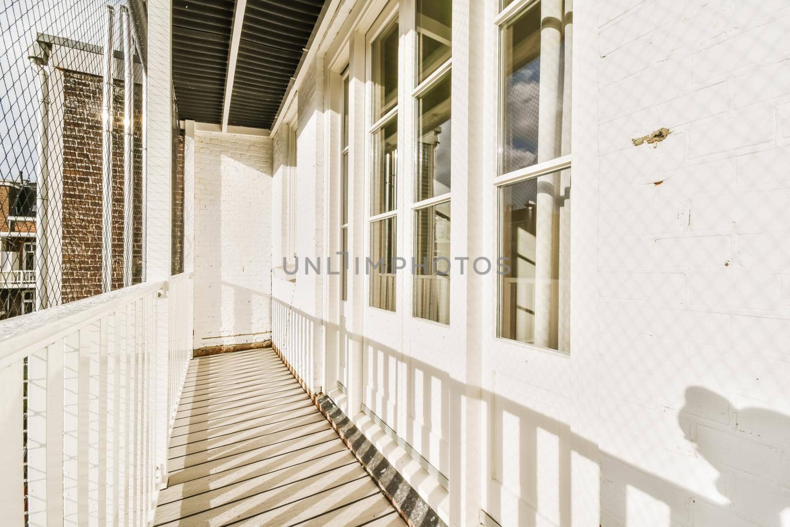 Long narrow balcony with white wooden railings