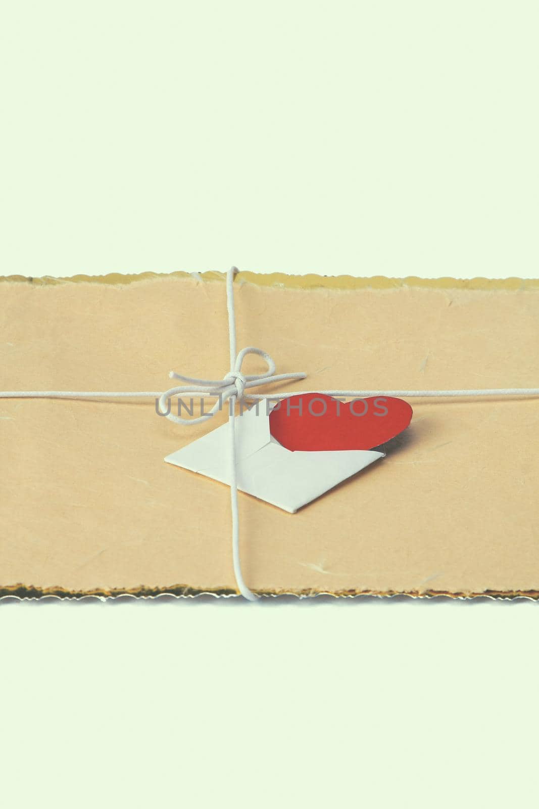 String bow with valentine card on brown packing paper.