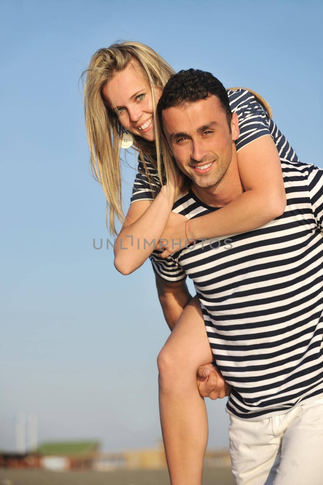 happy young couple have romantic time on beach at sunset