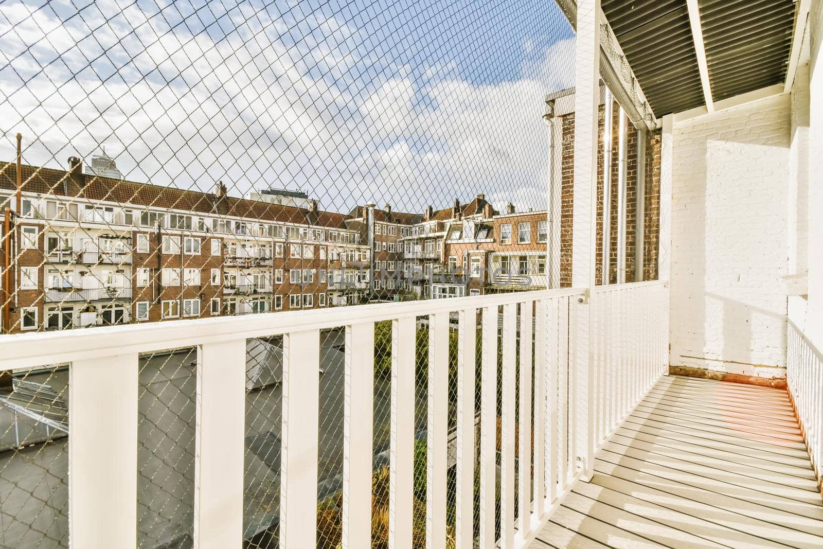 Long narrow balcony with white wooden railings