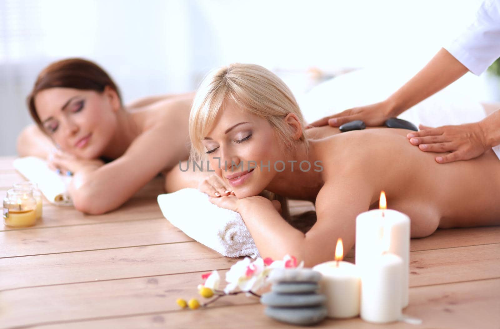 Two young beautiful women relaxing and enjoying at the spa center by lenetstan