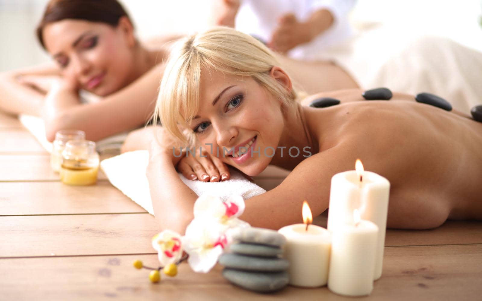 Two young beautiful women relaxing and enjoying at the spa center by lenetstan