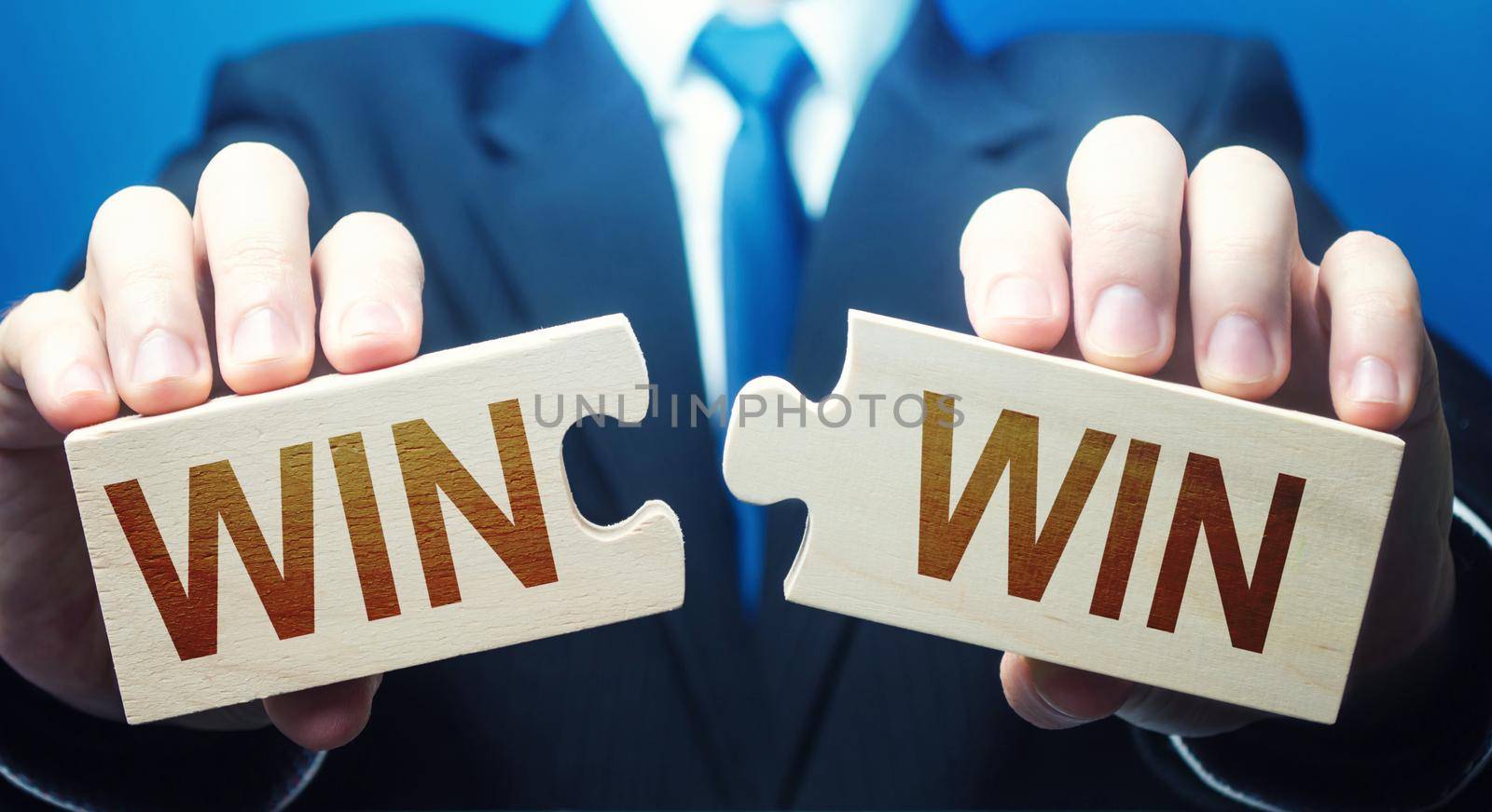 Man holding two puzzles with Win-Win words. A negotiation strategy makes all parties succeed. Mutual benefit and good contract terms. Compromise, perfect. Consent and satisfaction. Trade and diplomacy