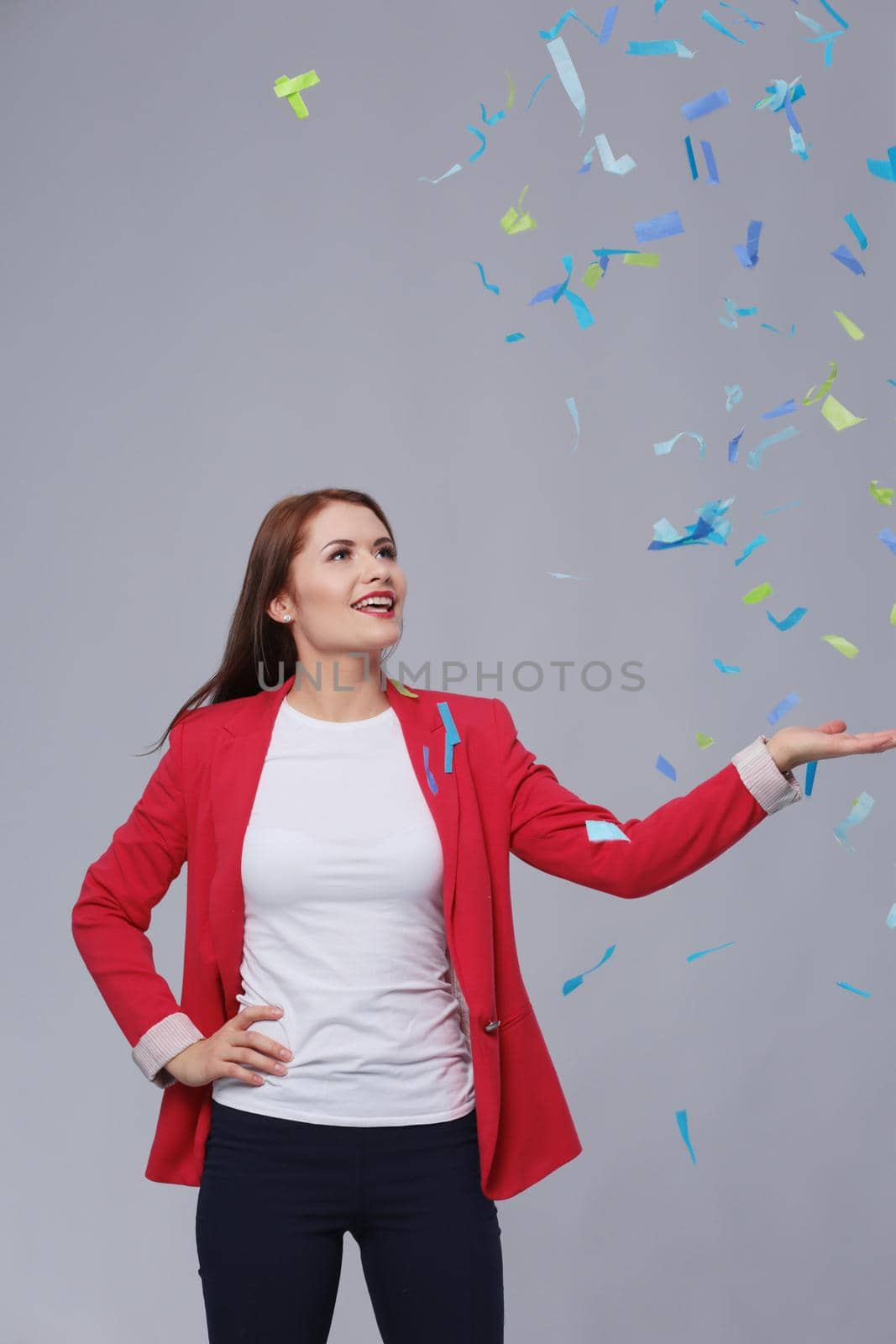 Beautiful happy woman at celebration party with confetti .Birthday or New Year eve celebrating concept. by lenetstan