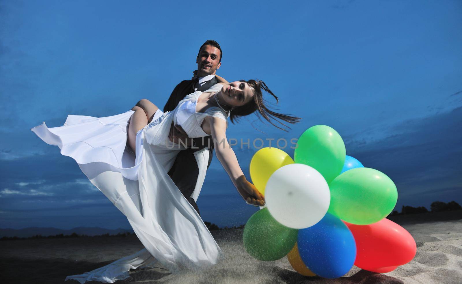 happy just married young couple celebrating and have fun at beautiful beach sunset