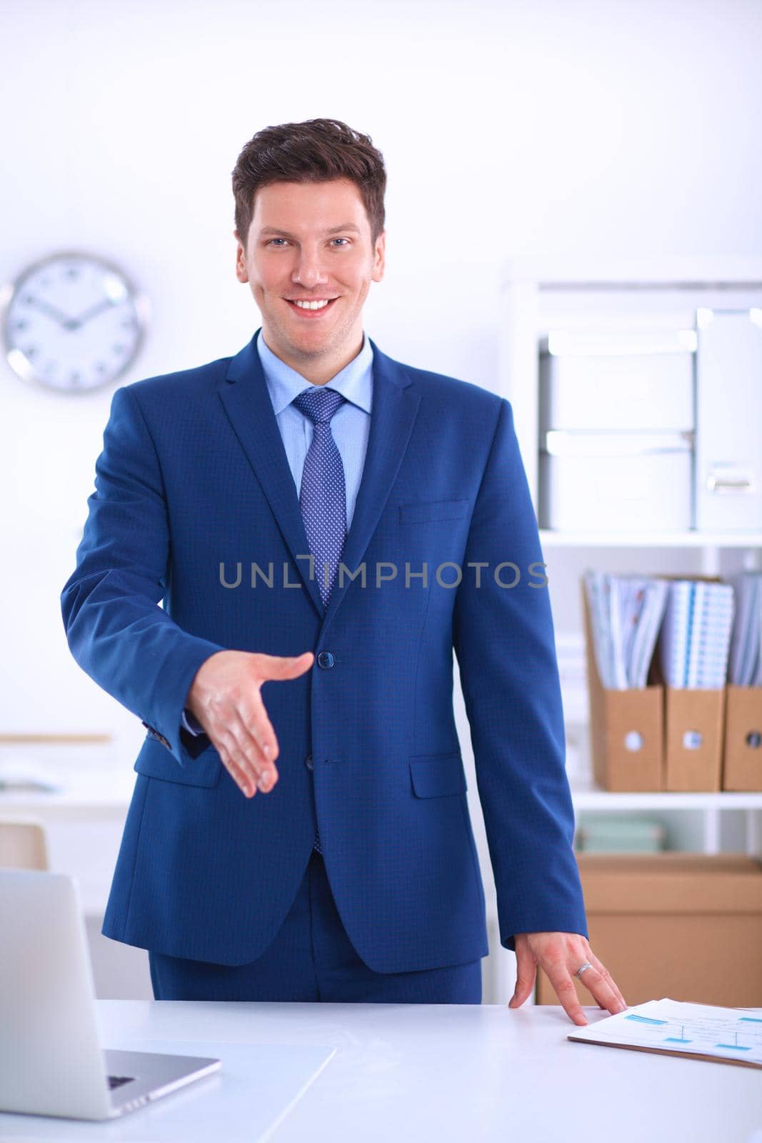 Business and office concept - handsome businessman with open hand ready for handshake by lenetstan