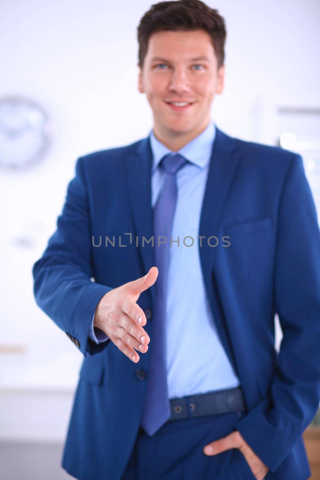 Business and office concept - handsome businessman with open hand ready for handshake by lenetstan