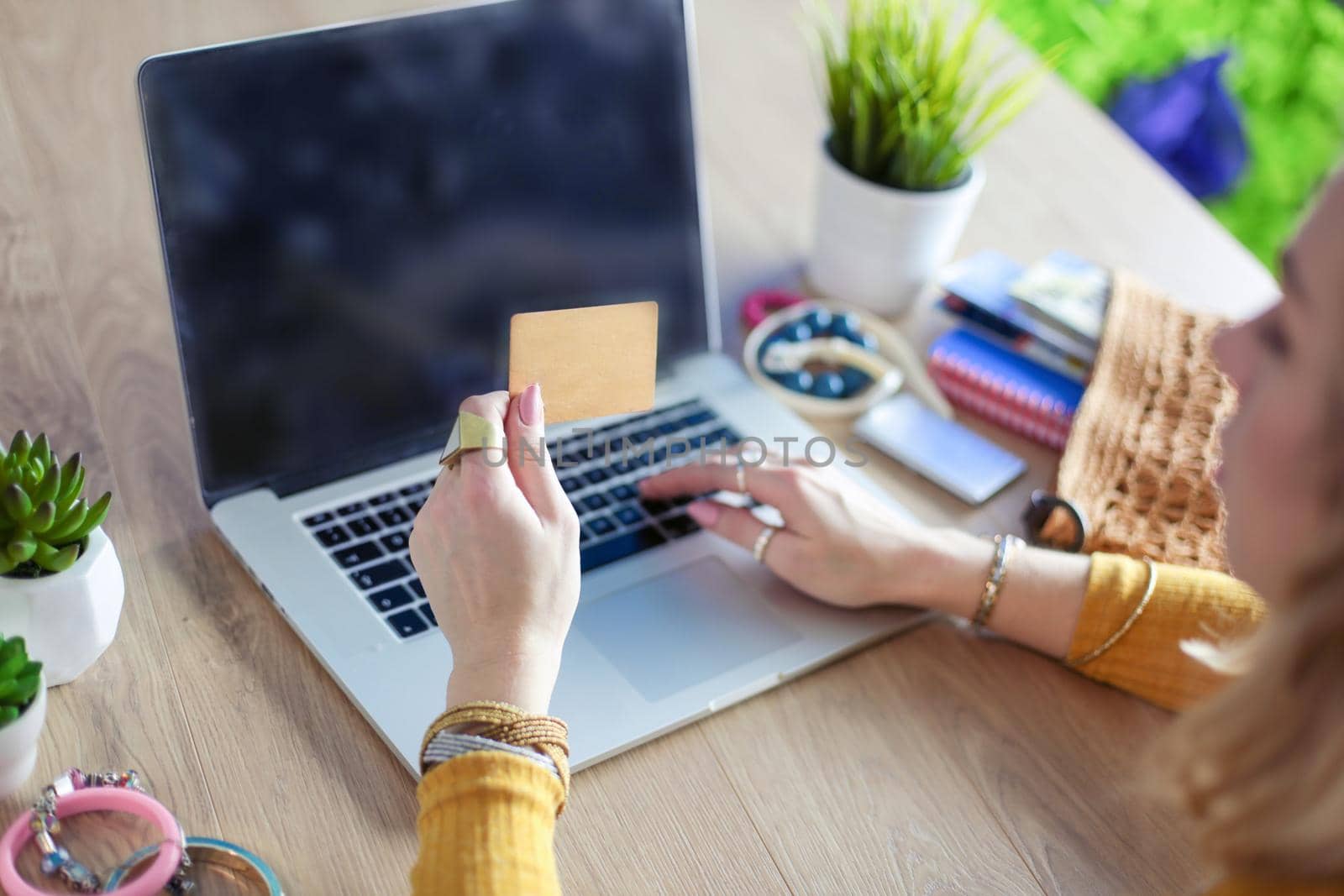 Young woman holding credit card and using laptop computer. Online shopping concept.