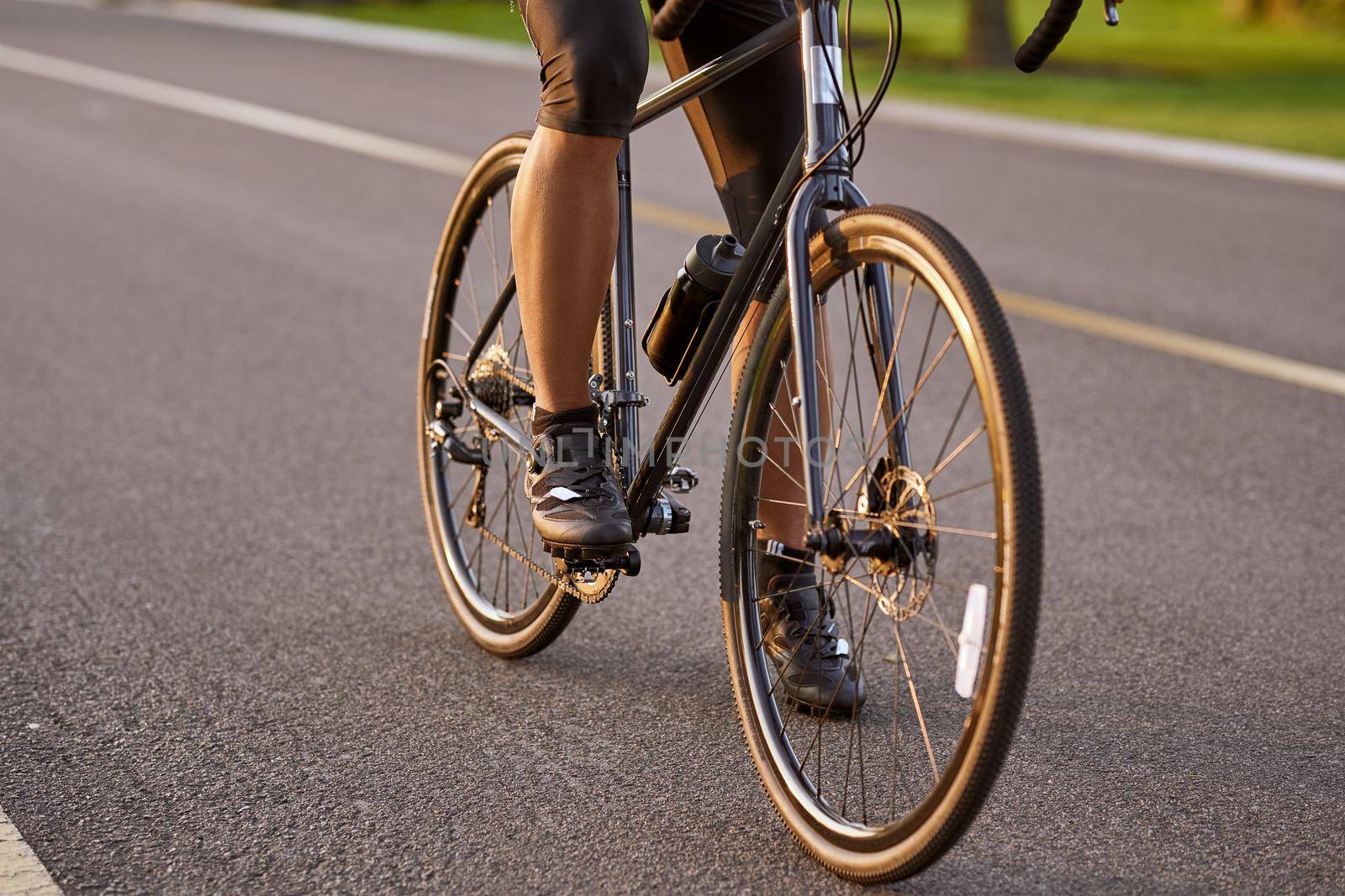 Riding. Cropped shot of a man cycling outdoors. Focus on male legs by friendsstock