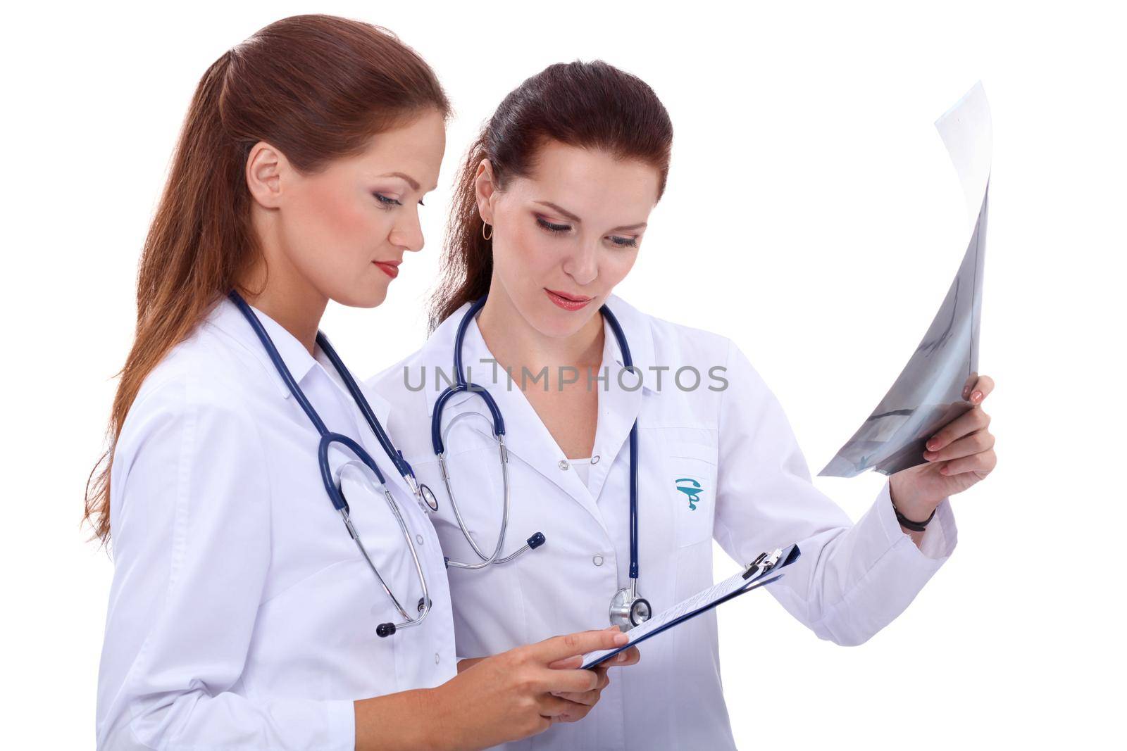 Two woman nurse watching X Ray image, standing in hospital by lenetstan