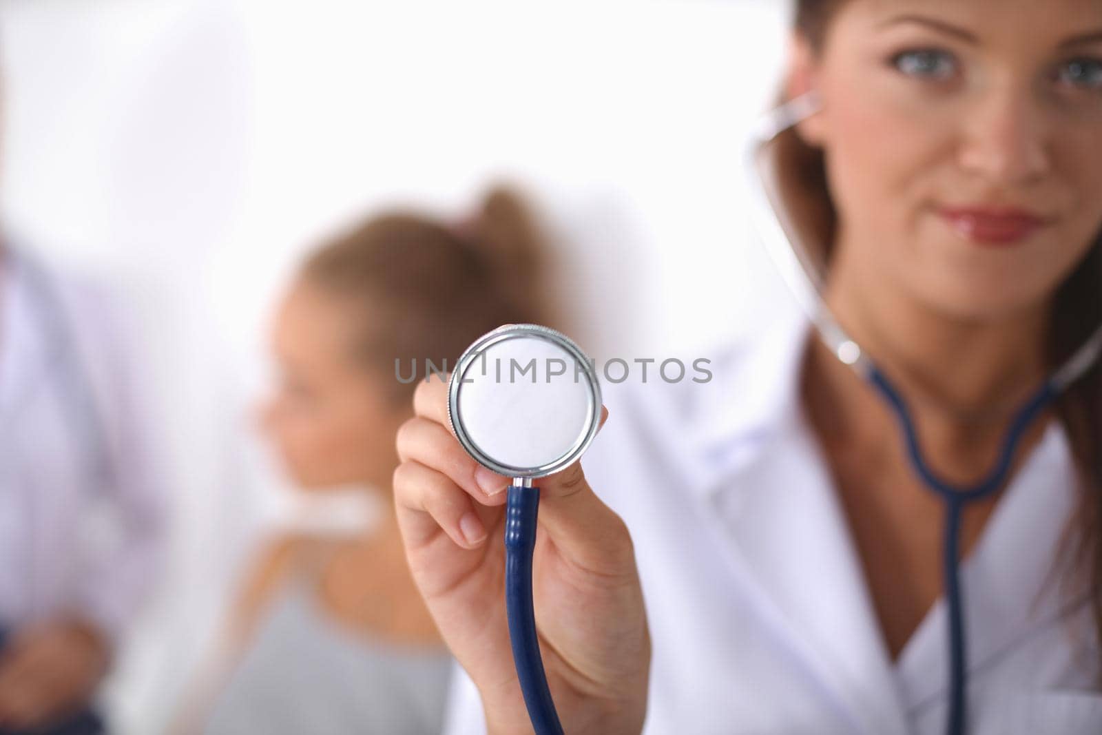 Smiling female doctor with a folder in uniform standing at hospital by lenetstan