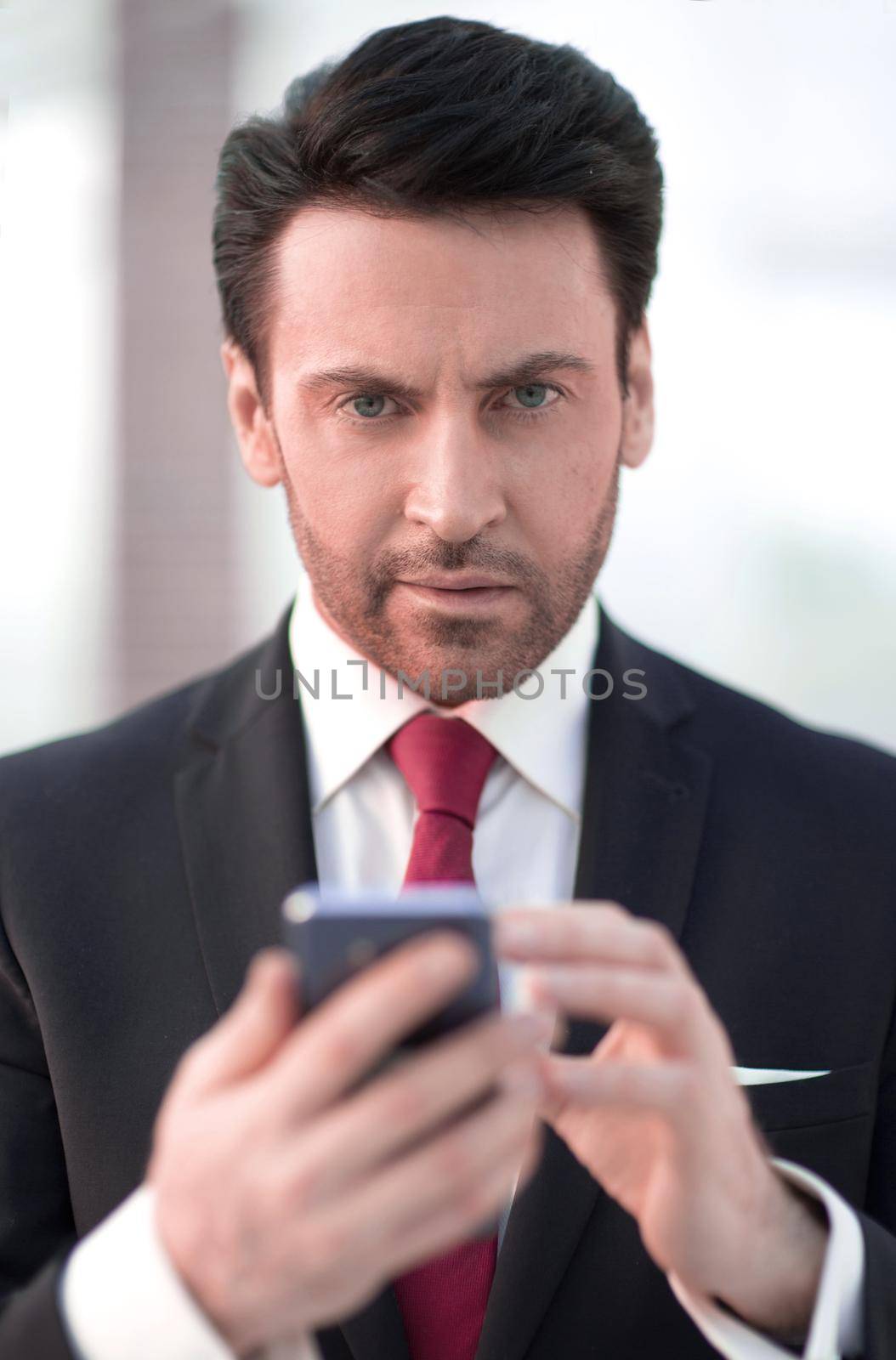 close up.businessman is typing SMS on a smartphone.people and technology
