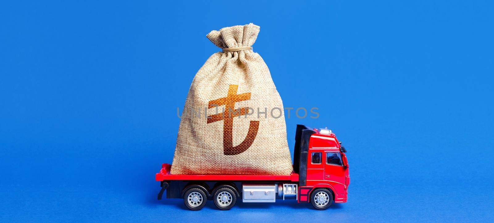 Truck is carrying a huge turkish lira money bag. Anti-crisis measures of government. Attracting large funds to the economy for subsidies, support and cheap soft loans for businesses. Great investment.