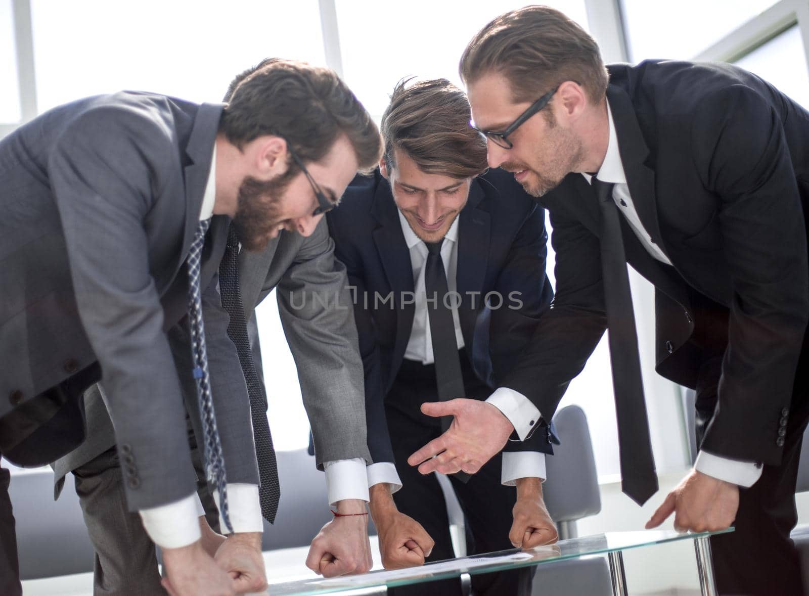 close up.a group of business people standing near the desktop by asdf