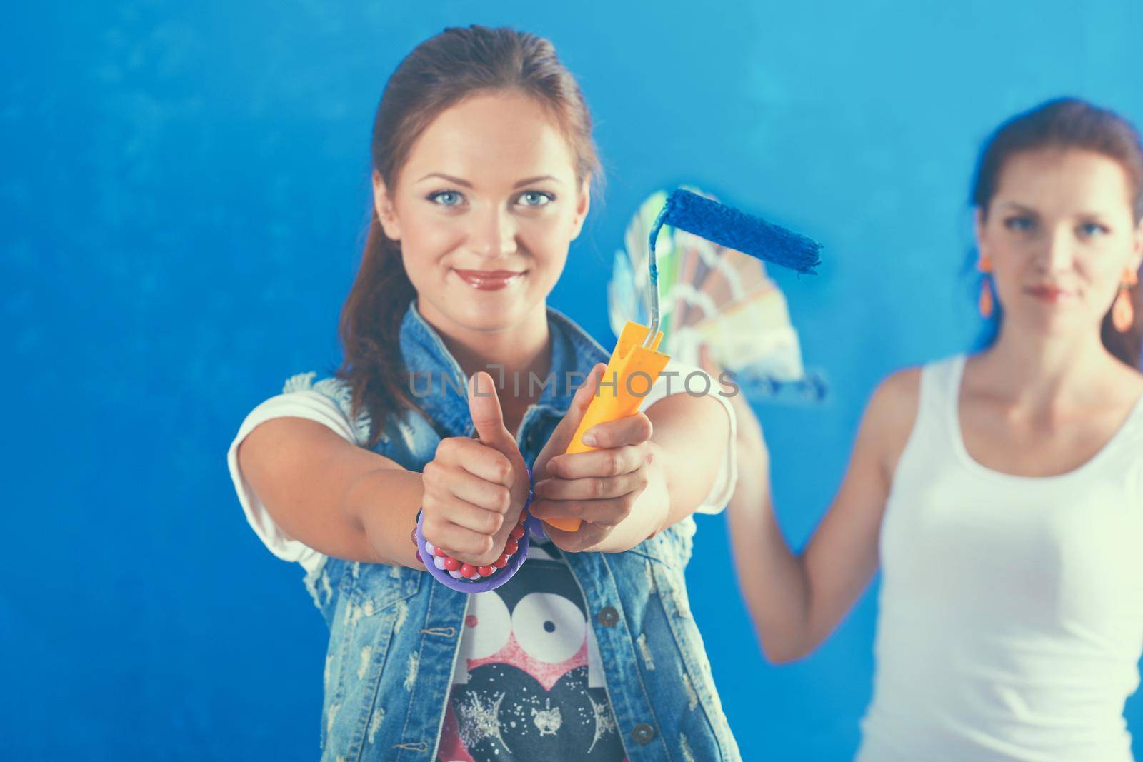 Two Beautiful young woman doing wall painting.