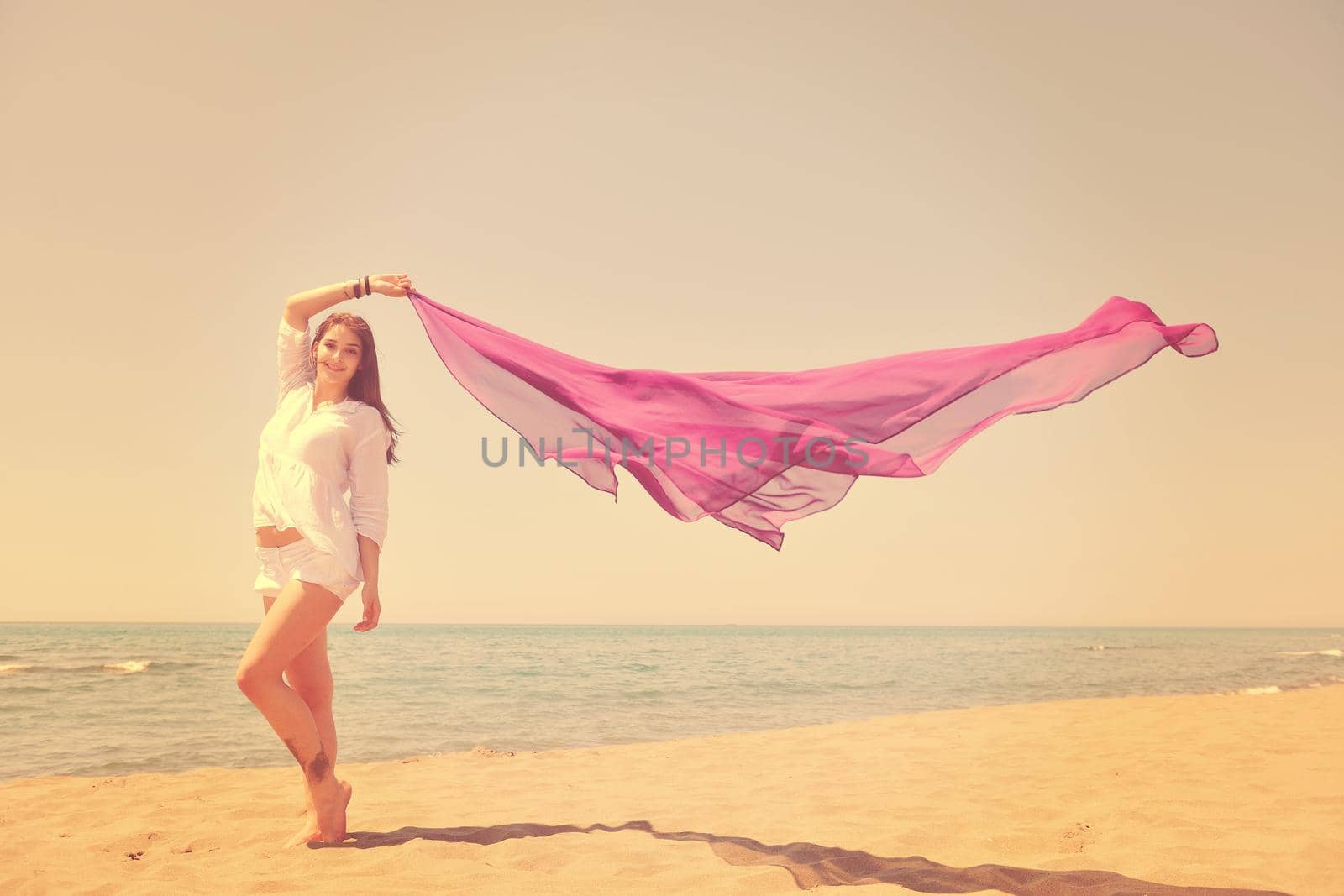 beautiful young woman on beach with scarf by dotshock