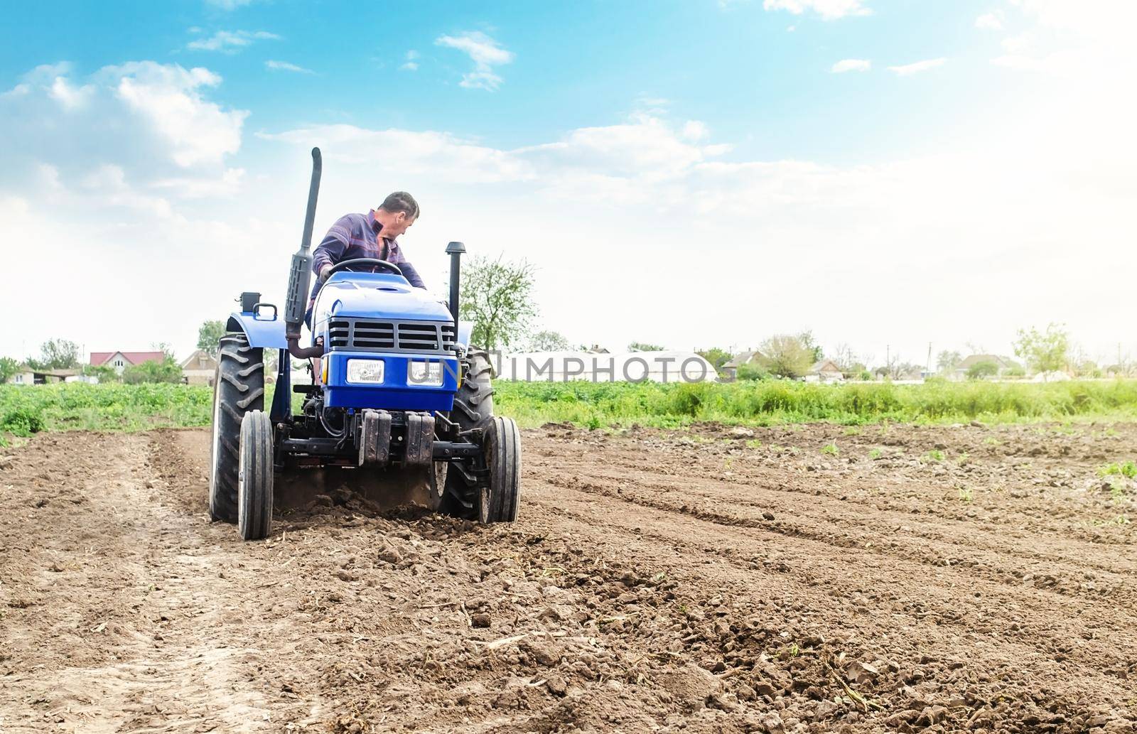 Farmer is processing soil on a tractor. Soil milling, crumbling mixing. Loosening surface, cultivating land for further planting. Agroindustry, farming. Agriculture, growing organic food vegetables