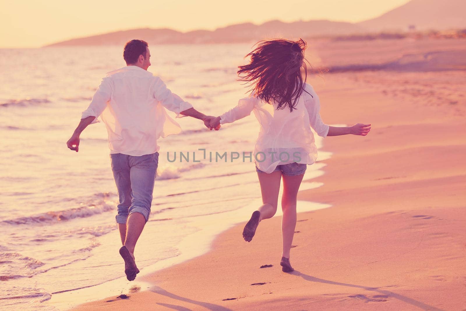 happy young romantic couple in love have fun on beautiful beach at beautiful summer day