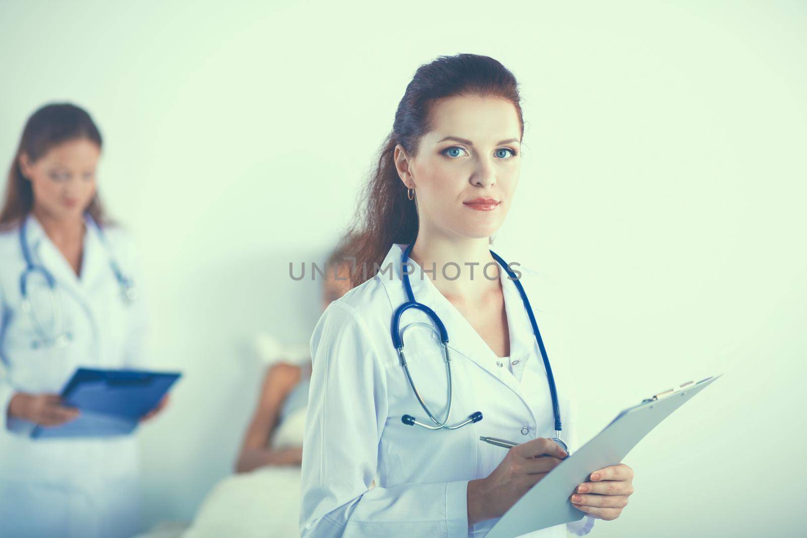 Woman doctor with folder standing at hospital.