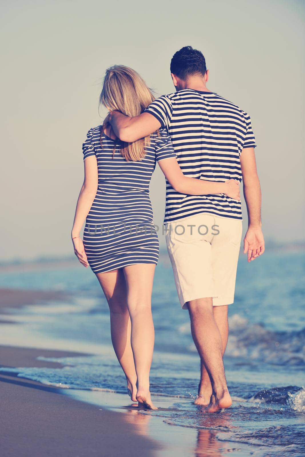 happy young couple have romantic time on beach at sunset