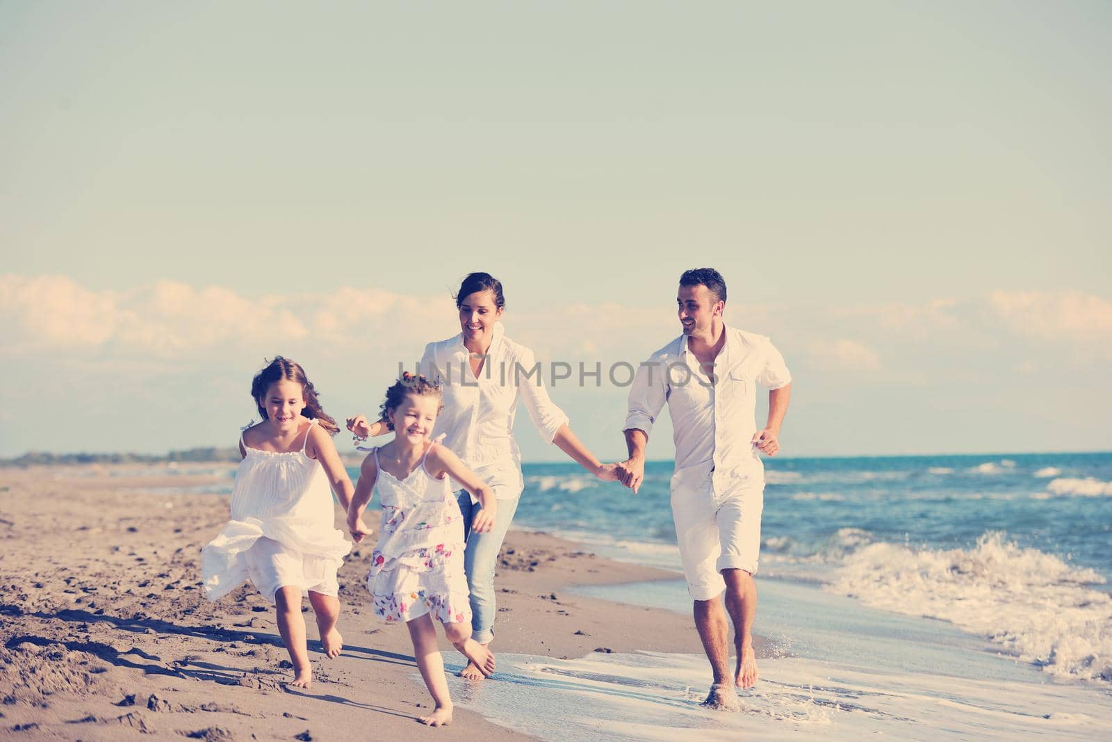 happy young  family have fun on beach by dotshock