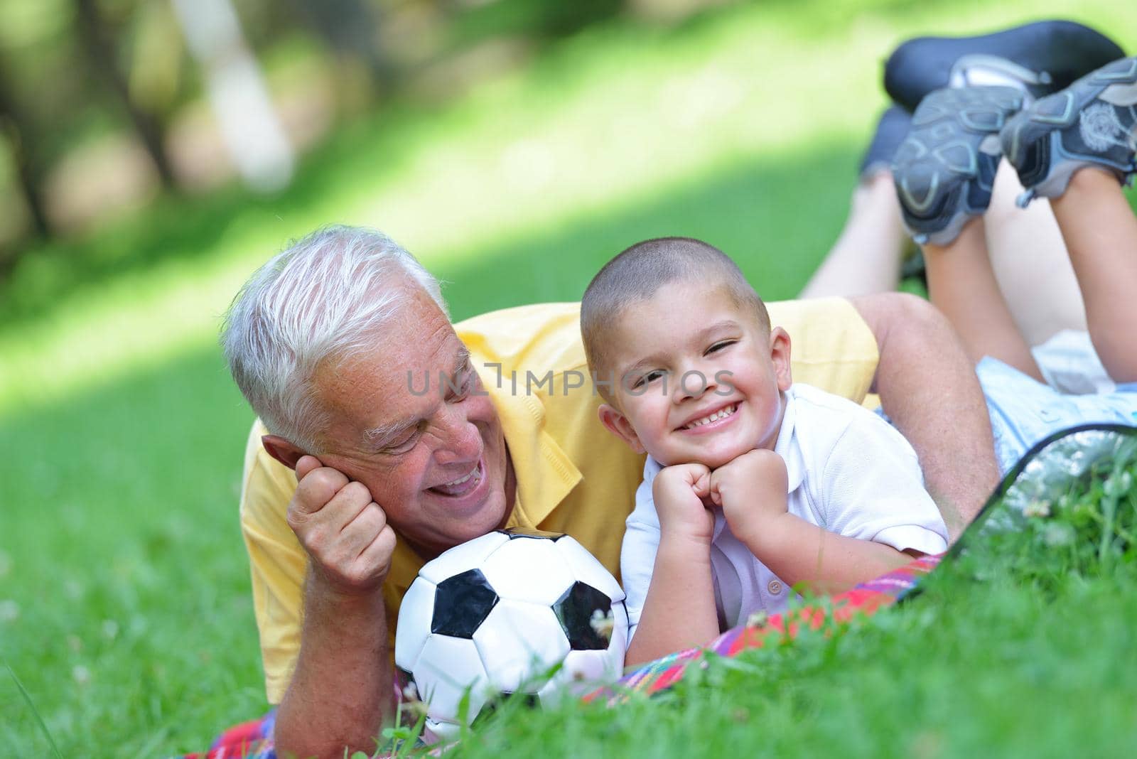 happy grandfather and child have fun and play in park