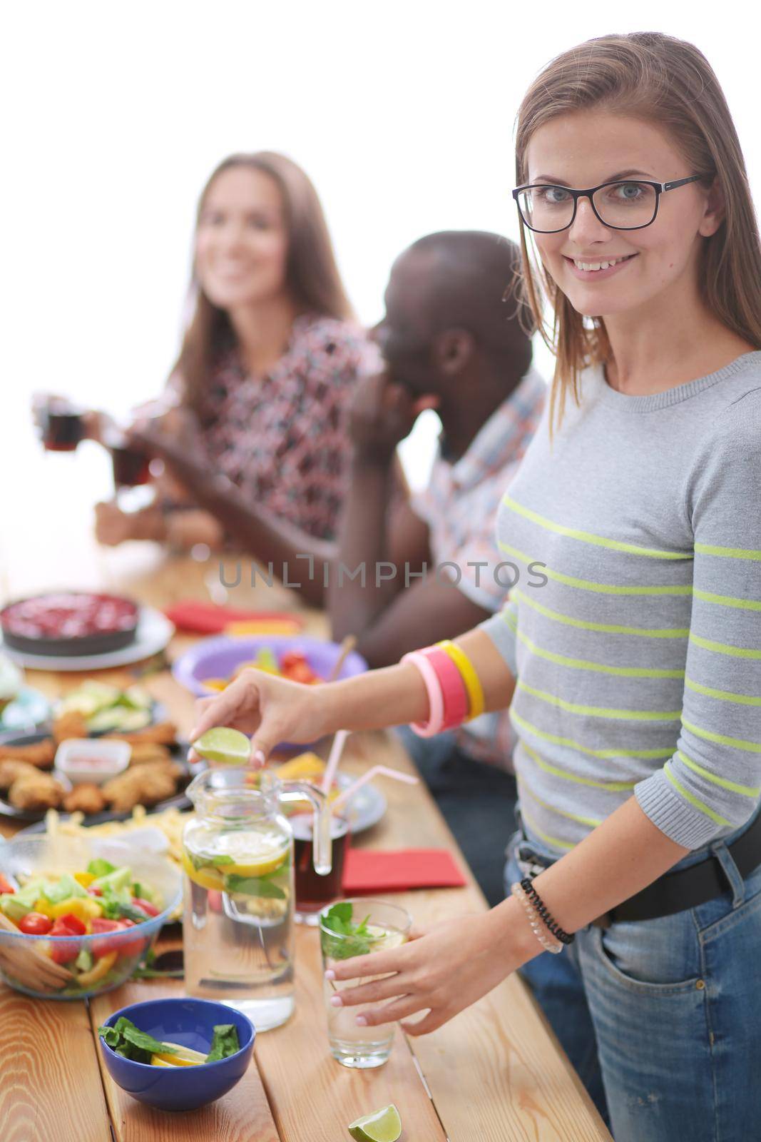 Top view of group of people having dinner together while sitting at wooden table. Food on the table. People eat fast food