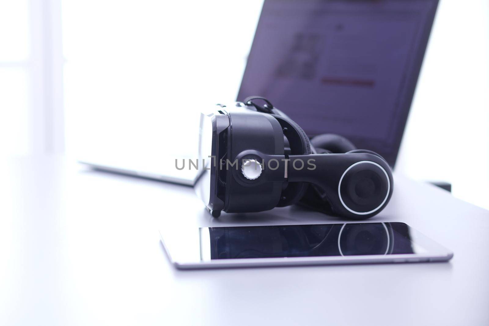 Virtual reality goggles on desk with laptop. business. 3d technology by lenetstan