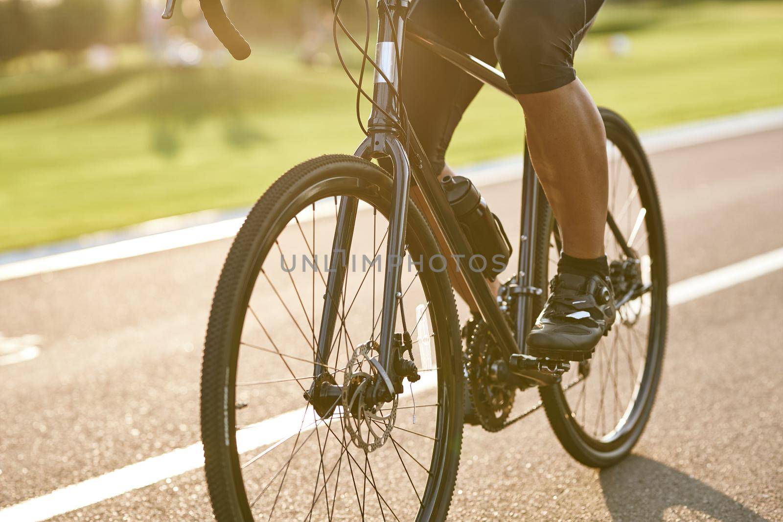 Close up shot of male cyclist legs, man cycling outdoors on a summer day. Active lifestyle concept