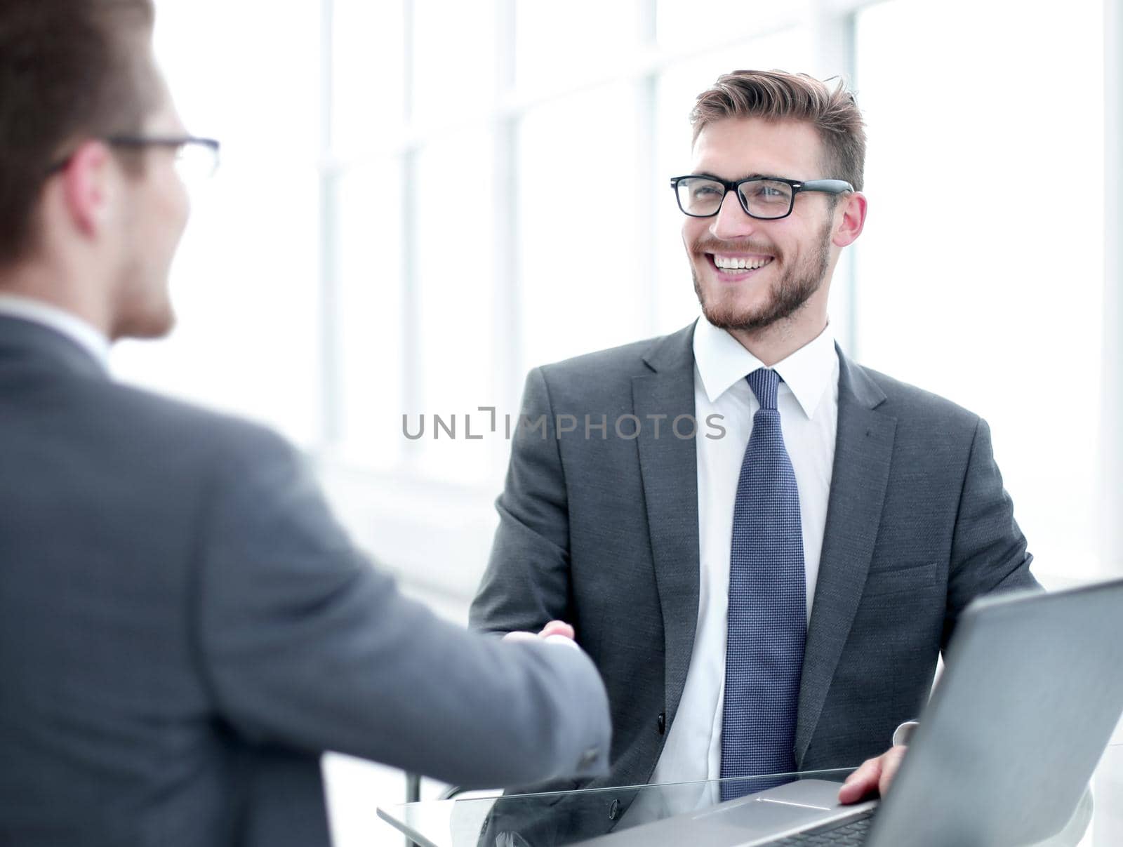 close up.smiling business people shaking hands in office.business concept